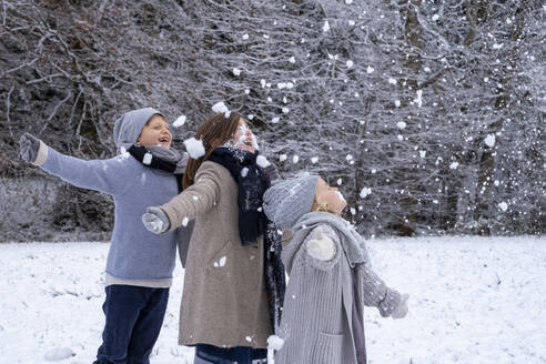 Fröhliche Geschwister in warmer Kleidung genießen den Schnee - LBF03714