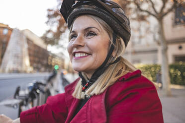 Fröhliche reife Frau mit Fahrradhelm - JCCMF09048