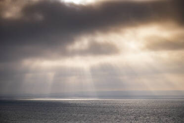 Sonnenstrahlen, die bei Sonnenuntergang durch Gewitterwolken auf das Meer fallen - SMAF02518