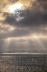 Sonnenlicht, das bei Sonnenuntergang durch Gewitterwolken auf eine Meereslandschaft fällt - SMAF02519