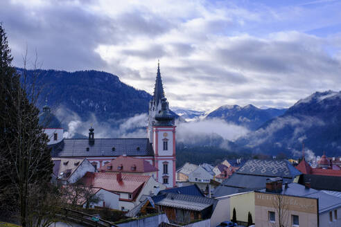 Österreich, Steiermark, Mariazell, Mariazeller Basilika und umliegende Häuser in nebliger Dämmerung - LBF03735