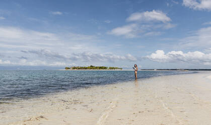 Junge Frau steht am Strand im Wasser, Insel Pontod, Philippinen - PNAF04967