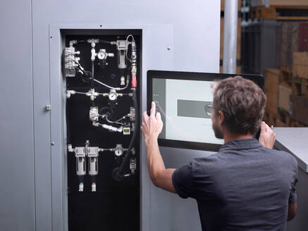 Techniker, der eine Maschine in einer modernen Fabrik bedient - CVF02278