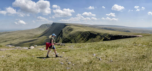 Frau beim Wandern in den Bergen an einem sonnigen Tag, Brecon Beacons, Wales - ALRF01936