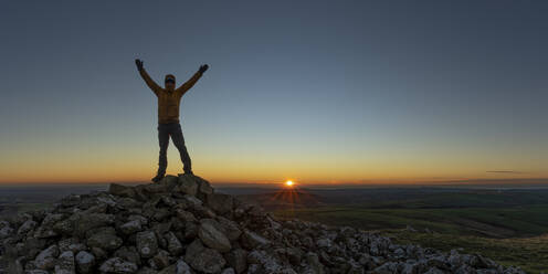 Mann mit erhobenen Armen auf einem Gipfel stehend, Preseli Hills, Pembrokeshire, Wales - ALRF01945