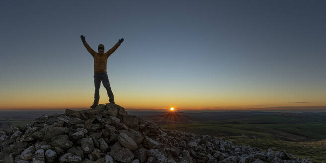 Mann mit erhobenen Armen auf einem Gipfel stehend, Preseli Hills, Pembrokeshire, Wales - ALRF01945