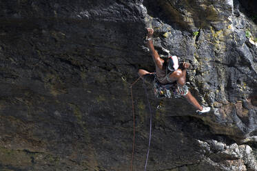 Man climbing rock at Huntsman's Leap, St Govan, Pembrokeshire, Wales - ALRF01976