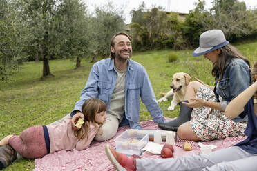 Glückliche Familie beim gemeinsamen Picknick auf einem Feld - EIF04210
