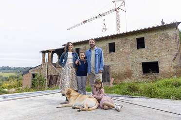 Happy family with dog in front of house - EIF04212