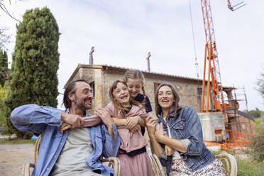 Happy family together having fun in front of house - EIF04235