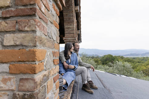 Glückliche reife Frau und Mann sitzen auf dem Dach - EIF04302