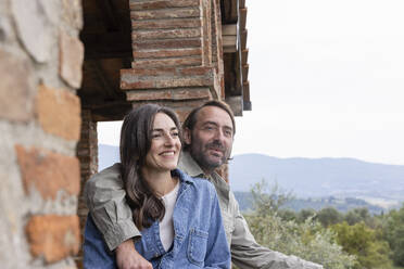 Happy woman with man sitting on rooftop - EIF04303