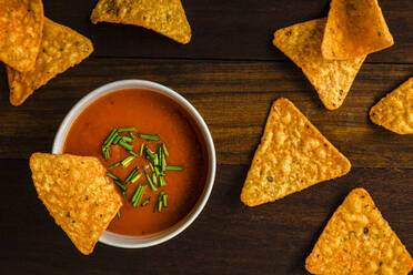 Nachos mit Tomatensauce auf dem Holztisch - FLMF00896