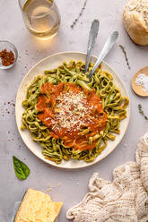 Spinach tagliatelle with tomato sauce served in plate on table - FLMF00919