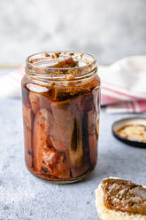 Homemade pickled eggplant preserved in glass jar kept on table - FLMF00922