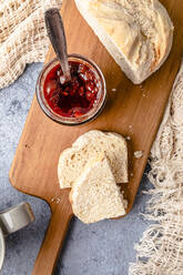 Homemade strawberry jam with bread on cutting board - FLMF00933