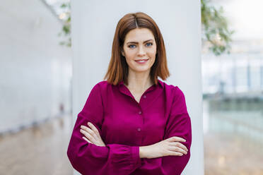 Smiling businesswoman standing with arms crossed - DIGF19689