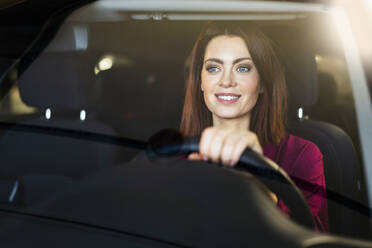 Smiling businesswoman driving car seen through windshield - DIGF19700