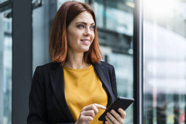 Thoughtful businesswoman with smart phone - DIGF19733