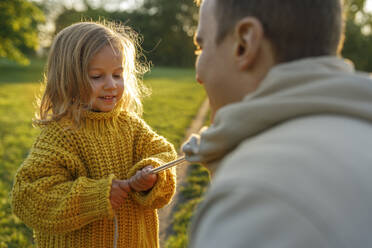 Cute girl playing with father in park - VIVF00333