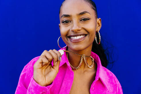 Young dancer wearing necklace in front of blue wall - OIPF03094