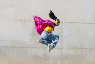 Junge Frau tanzt Hip Hop vor einer Wand - OIPF03103