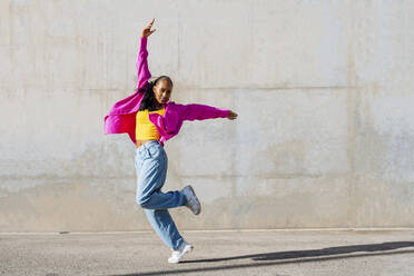 Dancer dancing with hand raised on footpath - OIPF03105