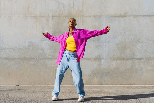 Young dancer with arms outstretched in front of wall - OIPF03107