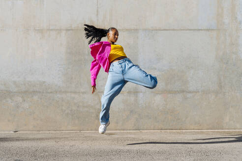 Young dancer hip hop dancing in front of wall - OIPF03111