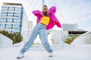 Confident young dancer breakdancing on footbridge - OIPF03129