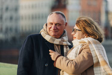 Senior woman wearing scarf talking to elderly man - VSNF00399