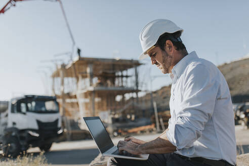 Architect using laptop at construction site - DMGF00989