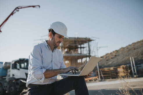 Älterer Architekt arbeitet am Laptop im Baubereich - DMGF00996