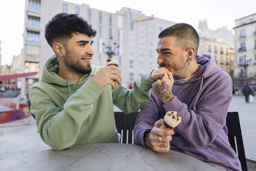 Gay man kissing boyfriend's hand at cafe - JCCMF09153