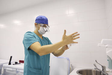 Doctor with tissue paper wiping hands at hospital - SANF00005