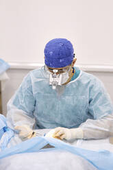 Chirurg bei der Augenoperation eines Patienten - SANF00006