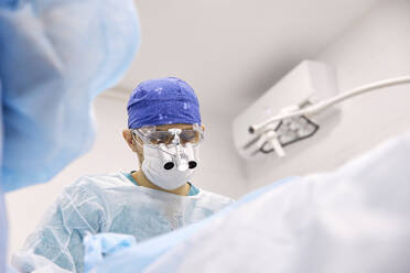 Chirurg führt eine Augenoperation an einem Patienten durch - SANF00014