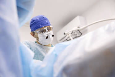 Arzt führt eine Augenoperation an einem Patienten durch - SANF00015