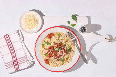 Draufsicht auf Teller mit Spaghetti Bolognese Nudeln mit Tomatensoße in weißem Tisch Hintergrund - ADSF42891