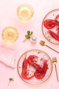 Von oben Glasplatte mit leckeren gebratenen Tiger Shrimps in der Nähe von Glas Wein auf dem Tisch rosa Hintergrund platziert - ADSF42897