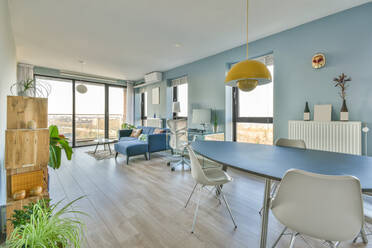 Interior of spacious minimalist style apartment and comfortable sofas placed near dining table in daylight - ADSF42939