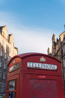 Von unten rote Telefonzelle mit königlichem Kronensymbol in der Nähe eines alten Gebäudes in einer Straße in Edinburgh, Schottland - ADSF43021