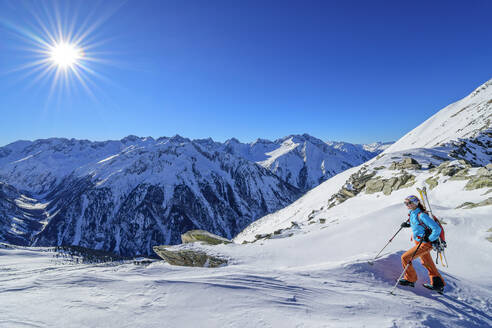 Österreich, Tirol, Sonnenschein über Skifahrerin in den Zillertaler Alpen - ANSF00217