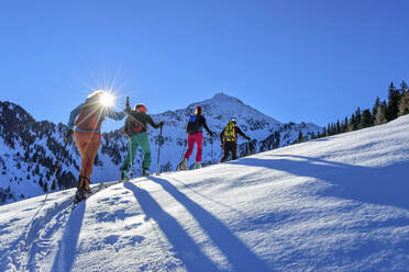 Österreich, Tirol, Gruppe von Skifahrern, die in einer Reihe über den Großen Galtenberg fahren - ANSF00221