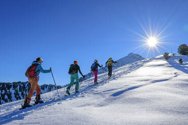 Österreich, Tirol, Gruppe von Skifahrern, die in einer Reihe über den Großen Galtenberg fahren - ANSF00223