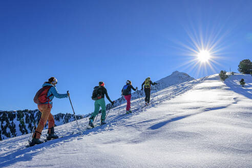 Austria, Tyrol, Group of skiers traveling in row across Grosser Galtenberg - ANSF00223