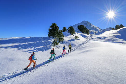 Österreich, Tirol, Gruppe von Skifahrern, die in einer Reihe über den Großen Galtenberg fahren - ANSF00224