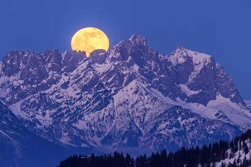 Austria, Tyrol, Yellow moon rising over Wiedersberger Horn at dusk - ANSF00231