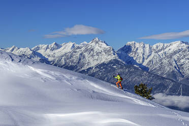 Austria, Tyrol, Female skier ascending snowcapped slope in Tux Alps - ANSF00242