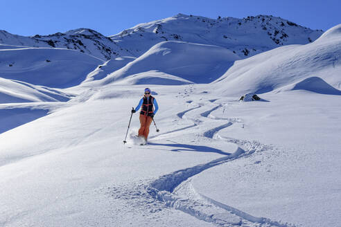 Österreich, Tirol, Skifahrerin rutscht schneebedeckten Hang in den Tuxer Alpen hinunter - ANSF00249